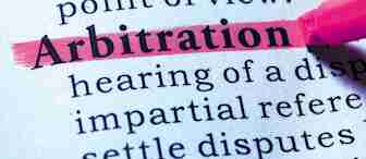 A close-up of a dictionary page with the word "Arbitration" highlighted in pink. The definition and surrounding text are slightly blurred, while the word "Arbitration" is sharp and clear, emphasizing its importance. A pink highlighter marker is visible nearby.