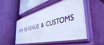 A stone building with a sign reading "HM Revenue & Customs" in capital letters is displayed in dark text on a light background. The sign is affixed to the wall with engraved lettering, indicating the government department responsible for tax and customs operations.