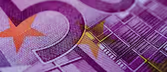 Close-up image of a 50 Euro banknote, highlighting the intricate design elements such as purple and orange hues, detailed line patterns, and yellow stars. The number "50" is prominently visible in large text.