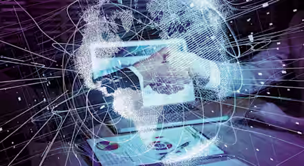 A futuristic image showing a person using a tablet. Surrounding the tablet and their hand are glowing, intricate digital lines and nodes forming a virtual network or globe, suggesting connectivity and advanced technology. A document with charts is on the table.