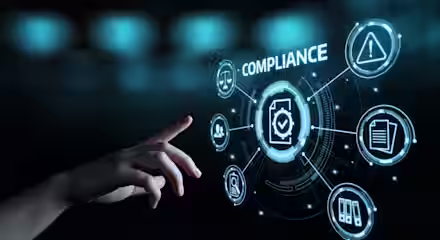 A hand reaches towards a digital interface displaying the word "COMPLIANCE" at the center. Surrounding icons represent various compliance aspects like warning signs, documents, and user profiles, all connected by futuristic lines and circles against a dark background.