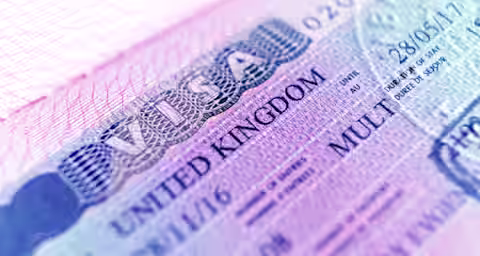 A close-up view of a visa document for the United Kingdom. The text on the visa includes the word "VISA" in large letters, followed by "UNITED KINGDOM". Various details such as dates, a unique visa number, and instructions are also visible on the document.