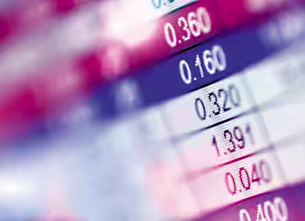 A close-up of a digital display showing rows of numbers, likely representing financial data such as stock market prices or exchange rates. The image features a mix of red, blue, and white colors, with the numbers in various formats like decimals.