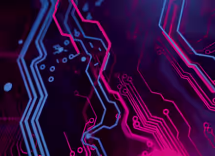 Close-up of a stylized, colorful circuit board with neon pink and blue lines and patterns on a dark purple background. The design features intricate pathways that create a dynamic, futuristic visual effect, resembling electronic circuitry.