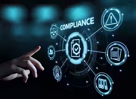 A hand reaches towards a digital interface displaying the word "COMPLIANCE" at the center. Surrounding icons represent various compliance aspects like warning signs, documents, and user profiles, all connected by futuristic lines and circles against a dark background.