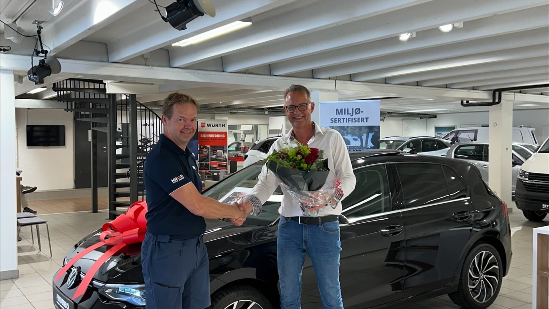 Salsleiar hos Frydenbø Bil, Kjell Snipsøyr (t.h.), gratulerer Andreas Leine med den nye Golf-en. – Ein solid kunde som har kjøpt veldig mange bilar hos oss, seier Snipsøyr.