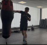 Image of new fitness manager throwing a right cross punch at the punching bag.