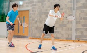 Males playing badminton ina sports hall