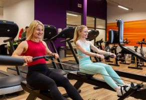 Two ladies in the gym on a rowing machine