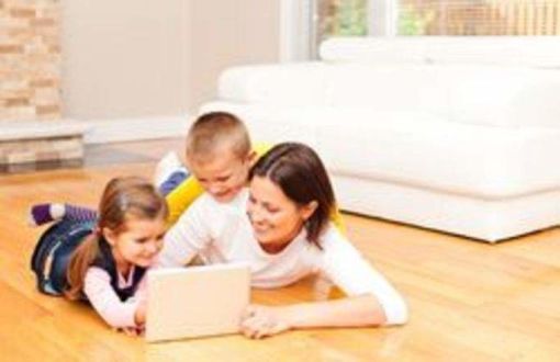 Carer and two children looking at a tablet