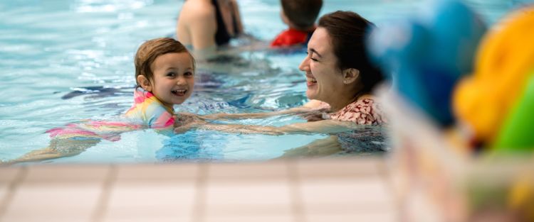 An image of a child and parent in a swimming lesson