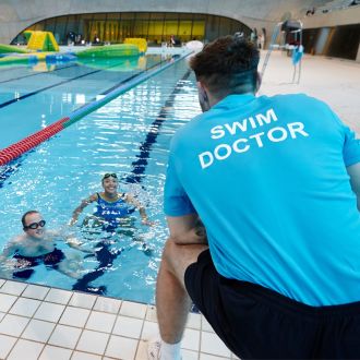 One of  Better's qualified swimming instructors discussing technique with a pair of swimmers