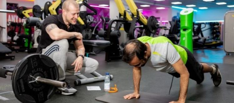 Fitness Instructor training a member in the gym