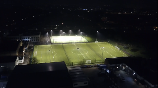 Night-time view of floodlit all weather pitch