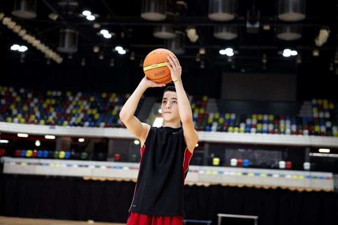 Teenage boy playing basketball
