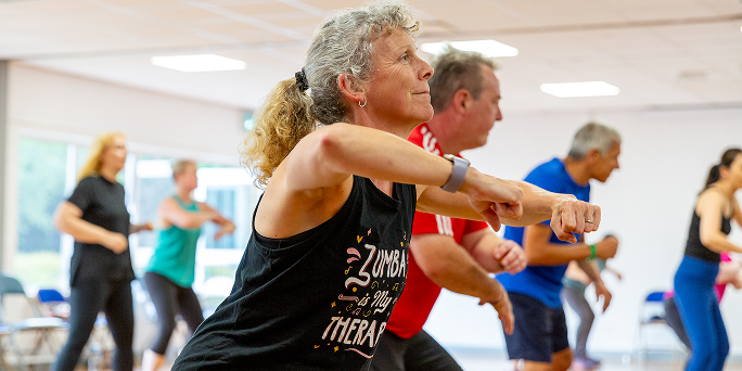 Close up on a Zumba instructor leading a class.