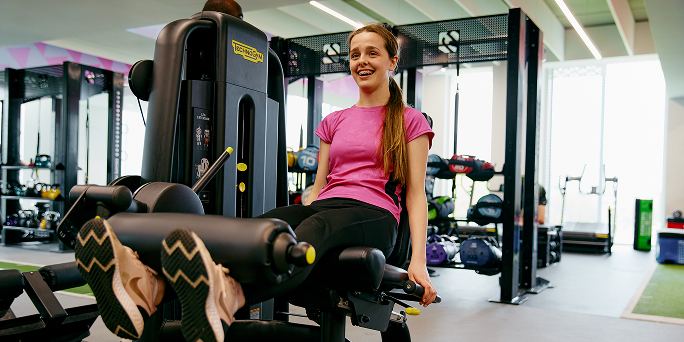 A teenage girl working out in the gym using gym equipment A teenage girl working out in the gym using gym equipment