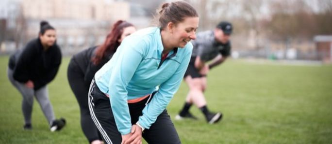 image shows a group of people exercising outdoors