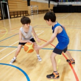 Two boys playing basketball