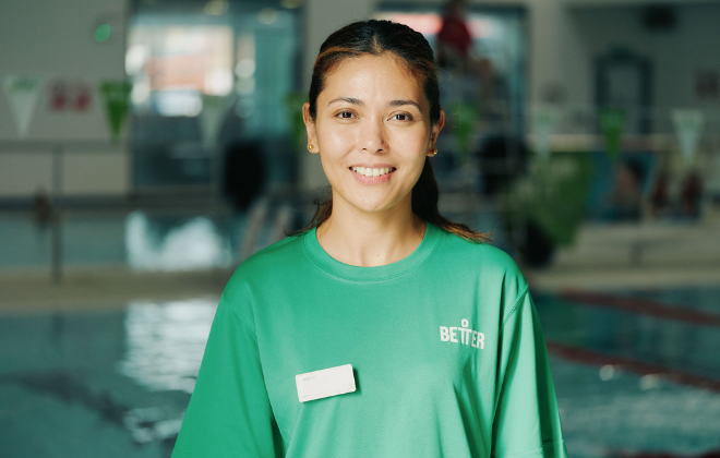 Swim school teaching standing smiling wearing a green t-shirt and badge
