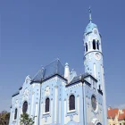 A Pale Blue and White Church with a Round Bell Tower