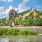 A Rocky Hillside with a Castle Near a River