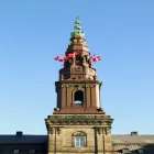 A Belltower with Danish Flags on Top