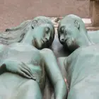 Two Side by Side Male and Female Sculptures Holding Hands