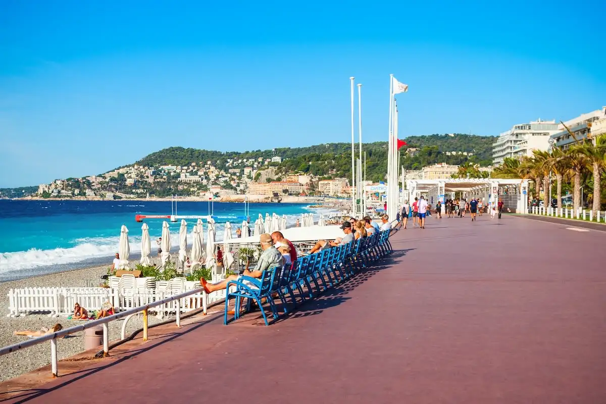 People sitting along Promenade des Anglais in Nice