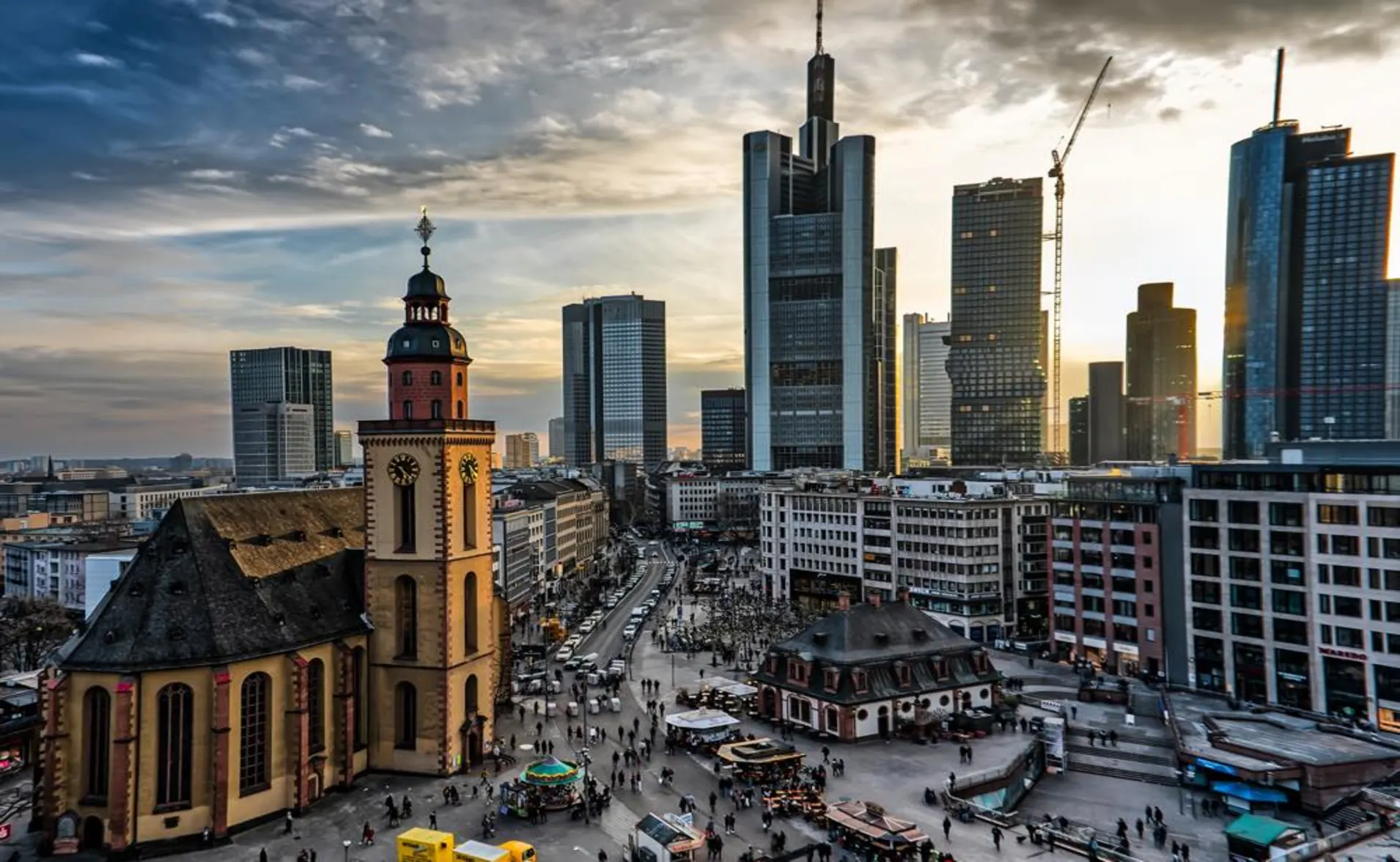 Skyscrapers and an old church at sunset in Frankfurt