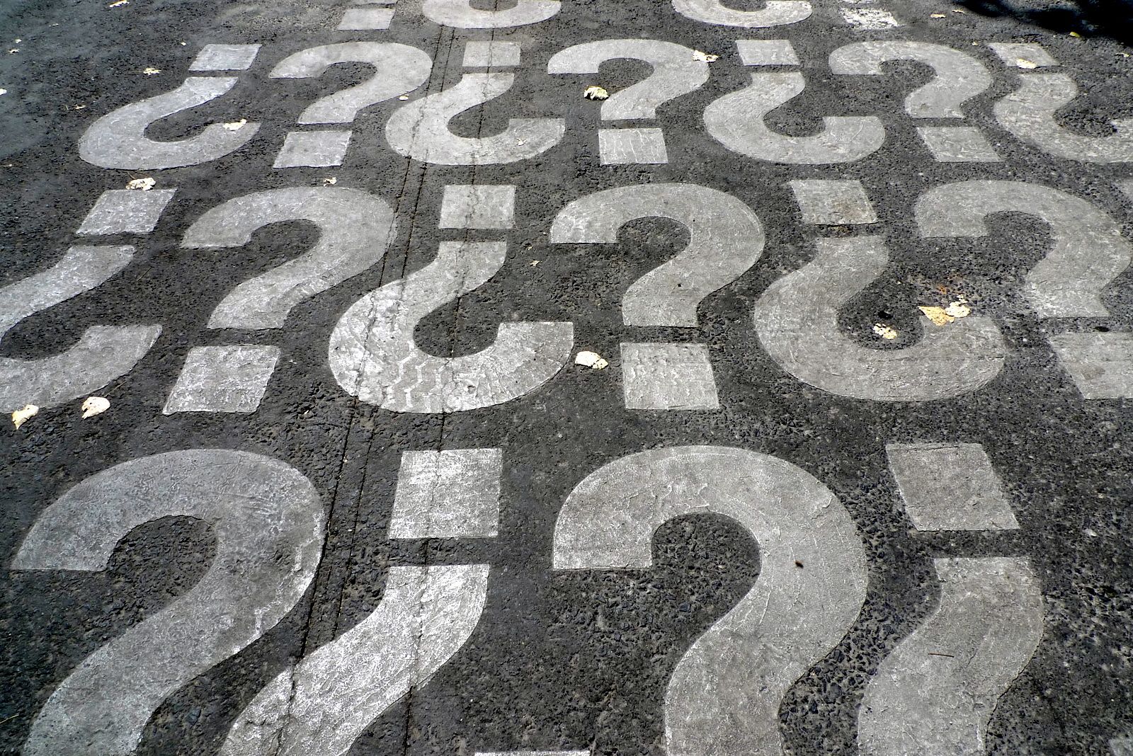 Question Marks Printed on Asphalt Pavement