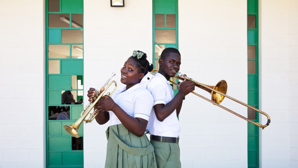 View of a boy and a girl playing musical instruments outside La Reference