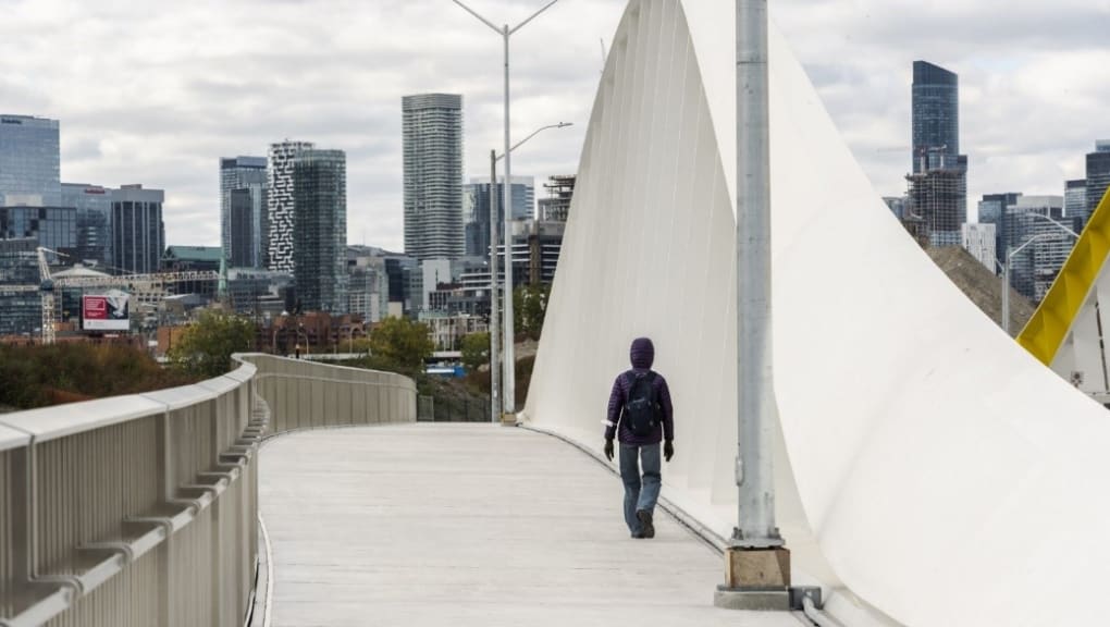 A person walking on the Port Lands Bridges. Copyright Waterfront Toronto, Vid Ingelevics, Ryan Walker, 2023