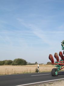 Packers - Kverneland Packomat compact and transported above ground level, dragged by tractor in a folded shape