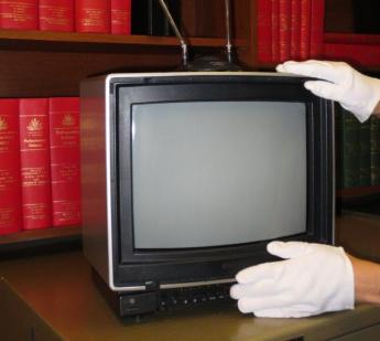 A curator installs the 1980s television in the speechwriters’ office in the Prime Minister’s Suite at the Museum of Australian Democracy at Old Parliament House. Museum of Australian Democracy Collection.