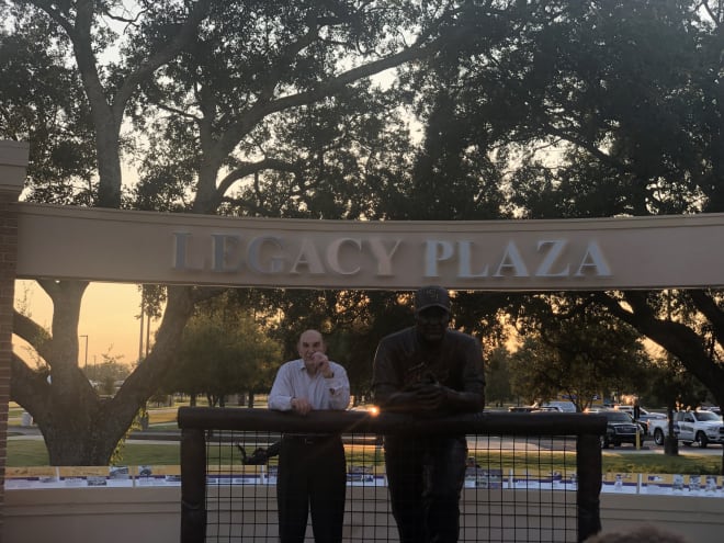 Former LSU baseball coach Skip Bertman poses with his new statue outside of Alex Box Stadium Friday evening