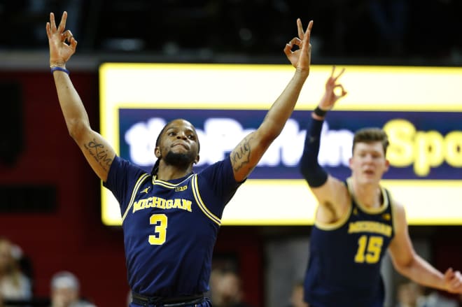 Michigan Wolverines guard Zavier Simpson and center Jon Teske celebrate against Rutgers Scarlet Knights