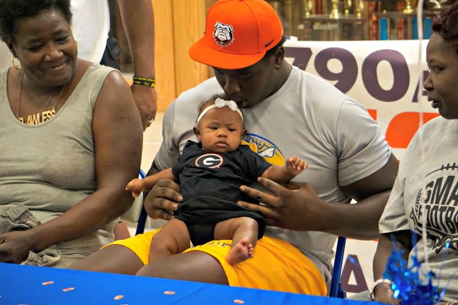 D'antne Demery shows off his four-month old daughter during Wednesday's announcement.