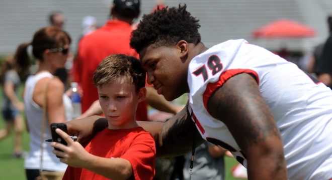 A young fan takes a selfie with Trenton Thompson last year at Sanford Stadium.