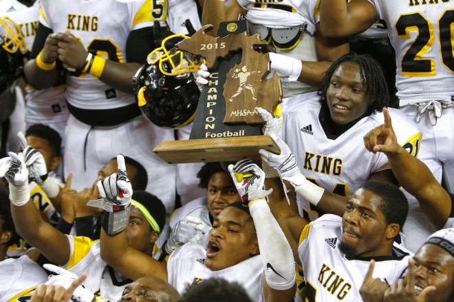 Detroit King players hoisting their 2015 state title trophy.