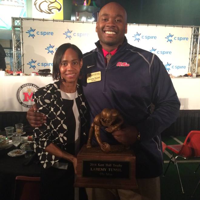 Desiree Tunsil Polingo and her son, former Ole Miss offensive tackle Laremy Tunsil, pose with the Kent Hull Trophy, awarded annually to the top college offensive lineman in Mississippi. Tunsil is expected to be one of the first five players selected when the NFL Draft begins Thursday in Chicago.