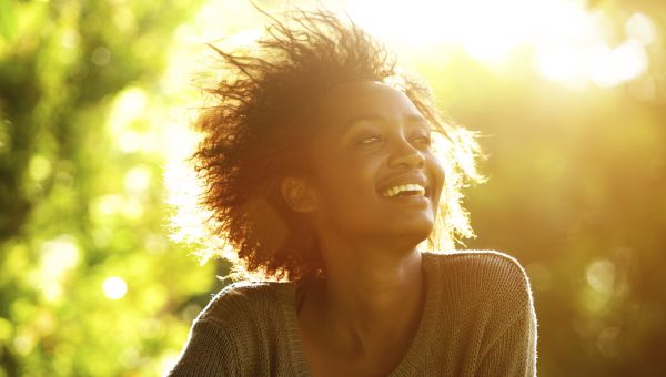 woman smiling in the sunshine outside