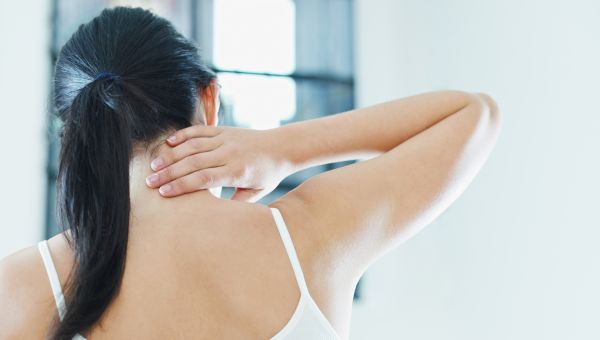 woman holding neck in pain