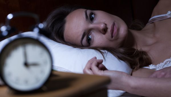 woman staring at alarm clock