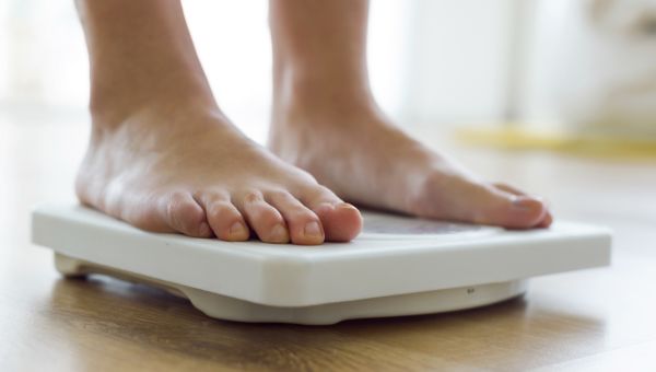 Young healthy girl on home scales.