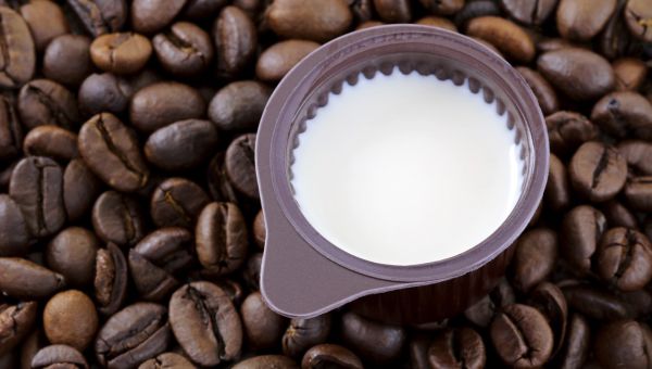 non-dairy creamer in a small bowl against a background of coffee beans
