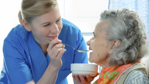 nurse feeding elderly patient