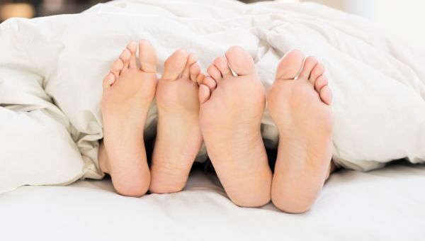 feet in bed, feet, bed, couple in bed, couple, white sheets