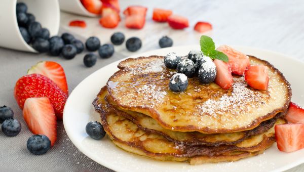 pancakes, blueberries, strawberries, powdered sugar, syrup, breakfast