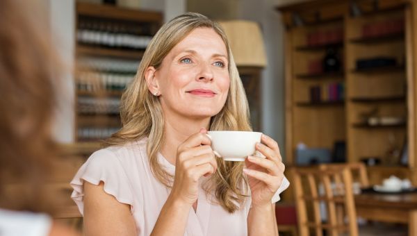 someone sipping hot tea, holding a mug